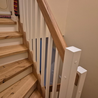Betonstiegenverkleidung aus Parkett mit Holzgeländer