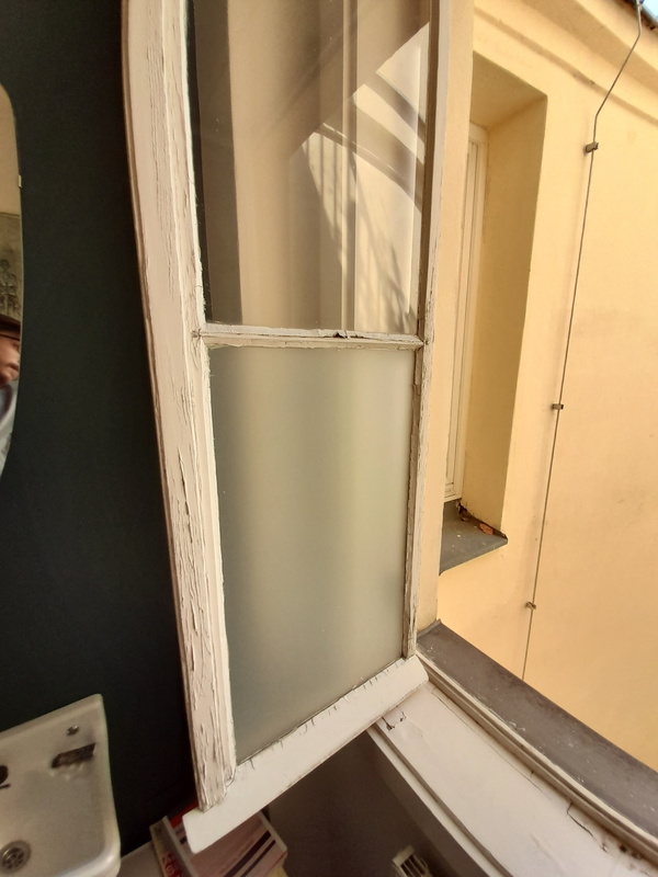 Kleine Lack- und Kittschäden an einem Kastenfenster
