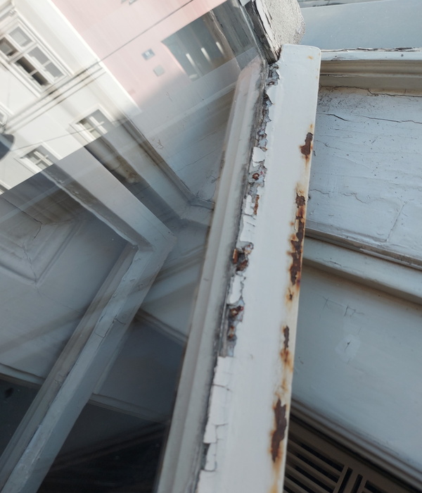 Stark abblätternder Lack an einem weißen Holzfenster
